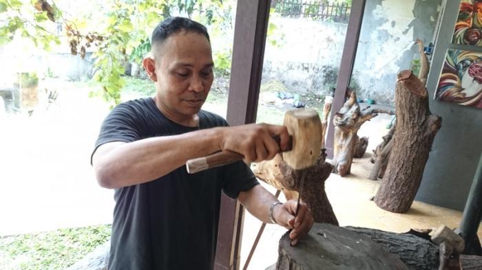 togu sinambela manfaatkan kayu bekas sebagai bahan seni
